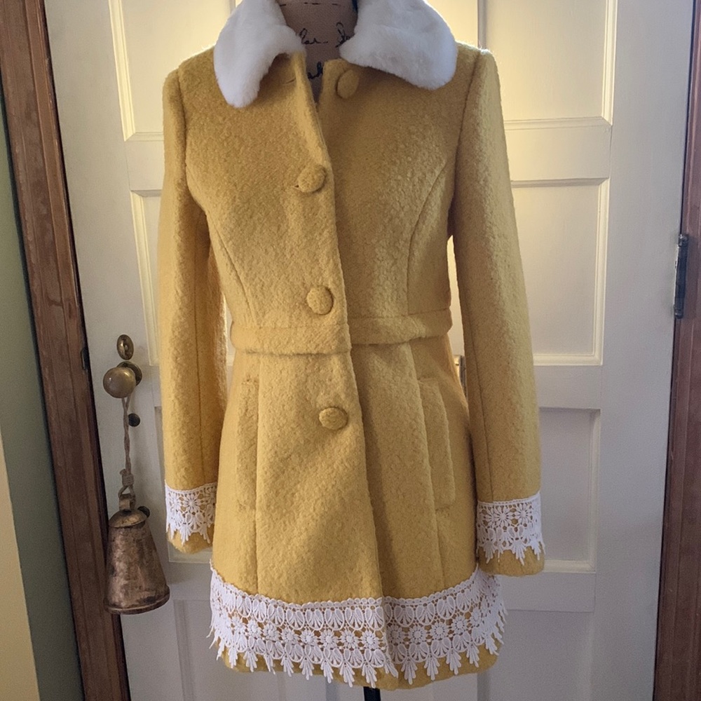 Boucle wool blend coat with embroidered lace detailing.